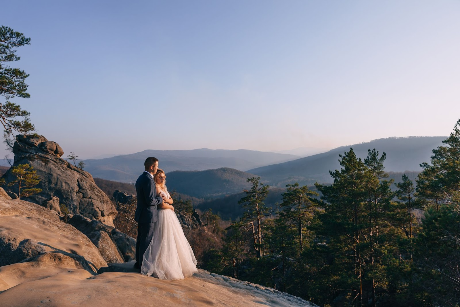 Chipeta-Lodge_Groom-Bride-Sunset-Peak - Chipeta Lodge Resort + Spa Bride in Groom's Arms eloping at sunset on rocky peak overlooking mountain valley near Chipeta Lodge Resort + Spa