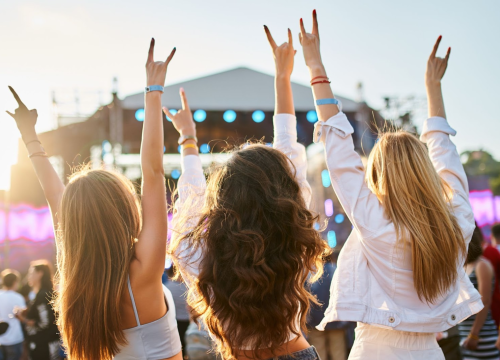 3 women with raise arms at an outdoor concert near Chipeta Lodge Resort + Spa