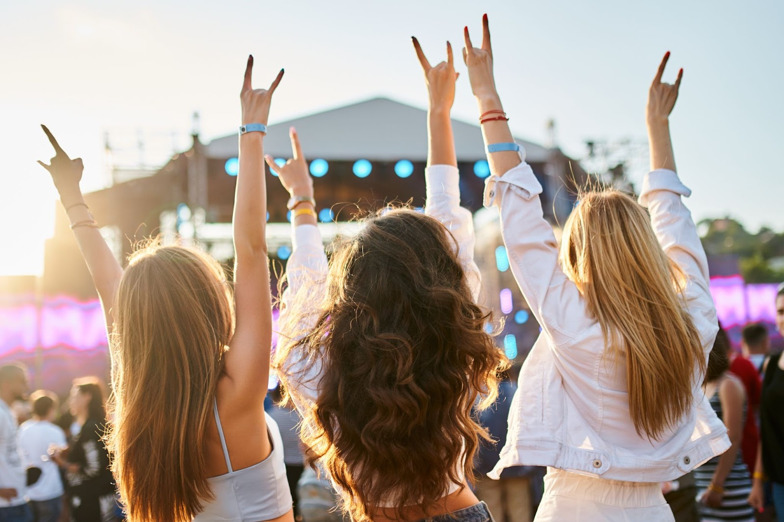 3 women with raise arms at an outdoor concert near Chipeta Lodge Resort + Spa