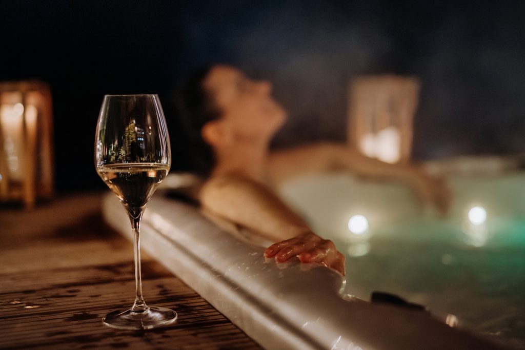Woman enjoying a glass of wine and a soak in the hote tub at Chipeta Lodge Resort + Spa
