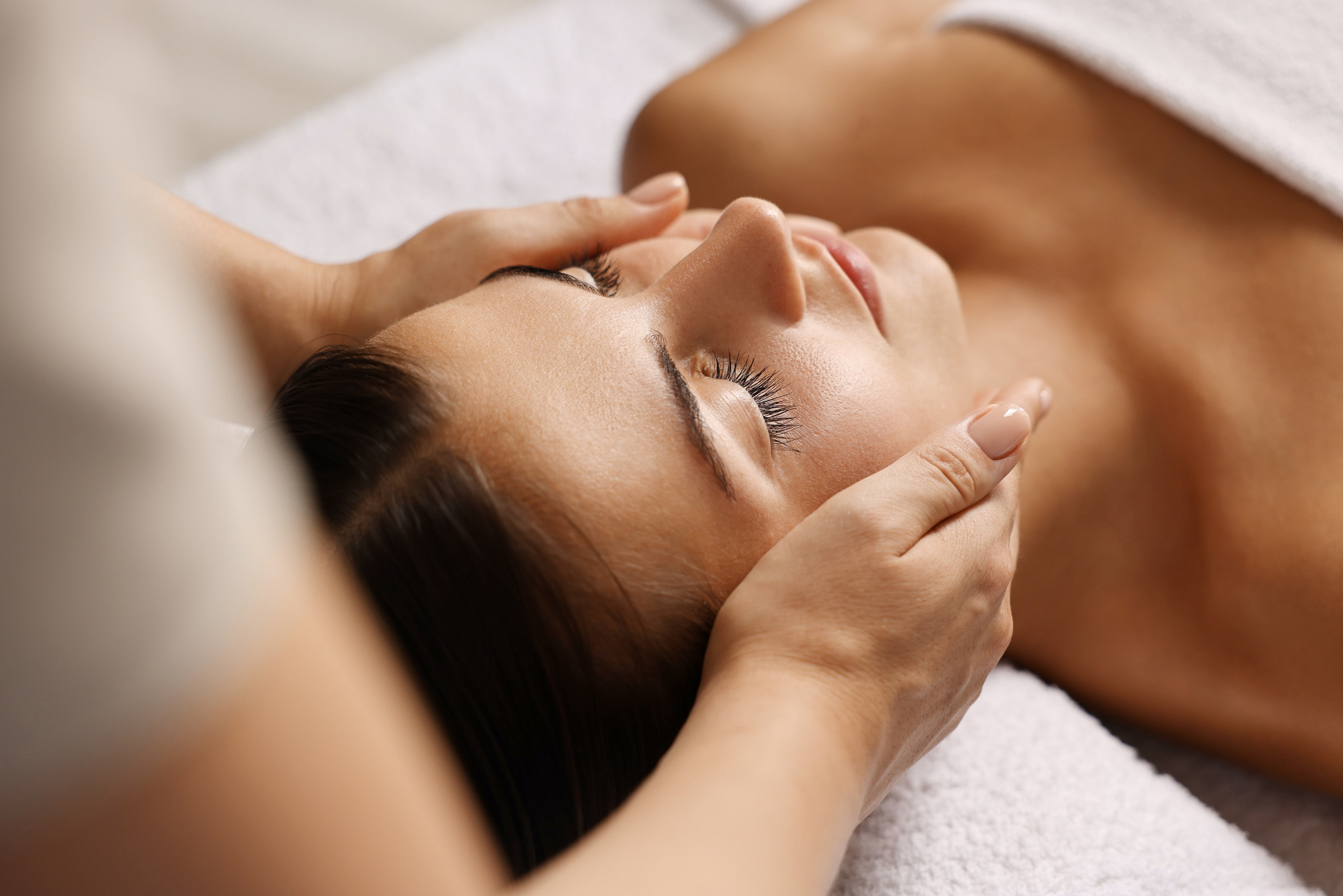 Attractive woman enjoying face massage closeup Beauty procedure Woman's facial at the Chipeta Lodge Spa by ISUN
