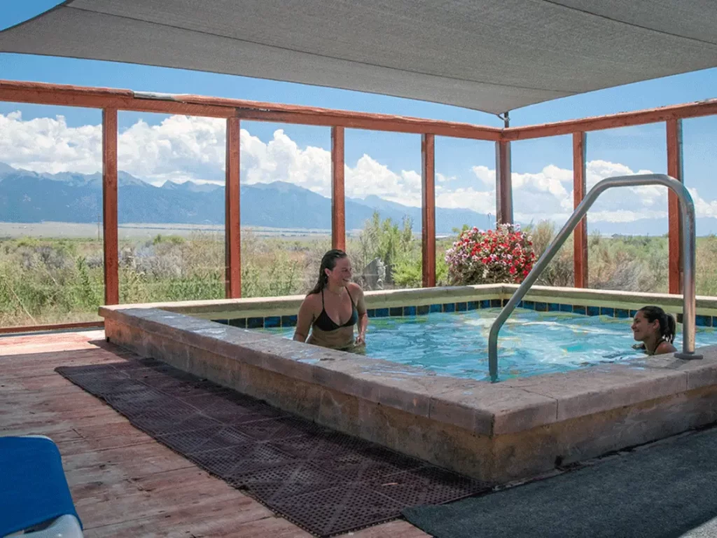 Two women in the shady pool at Joyful Journey Hot Springs on the Hot Springs Loop near Chipeta Lodge Resort + Spa