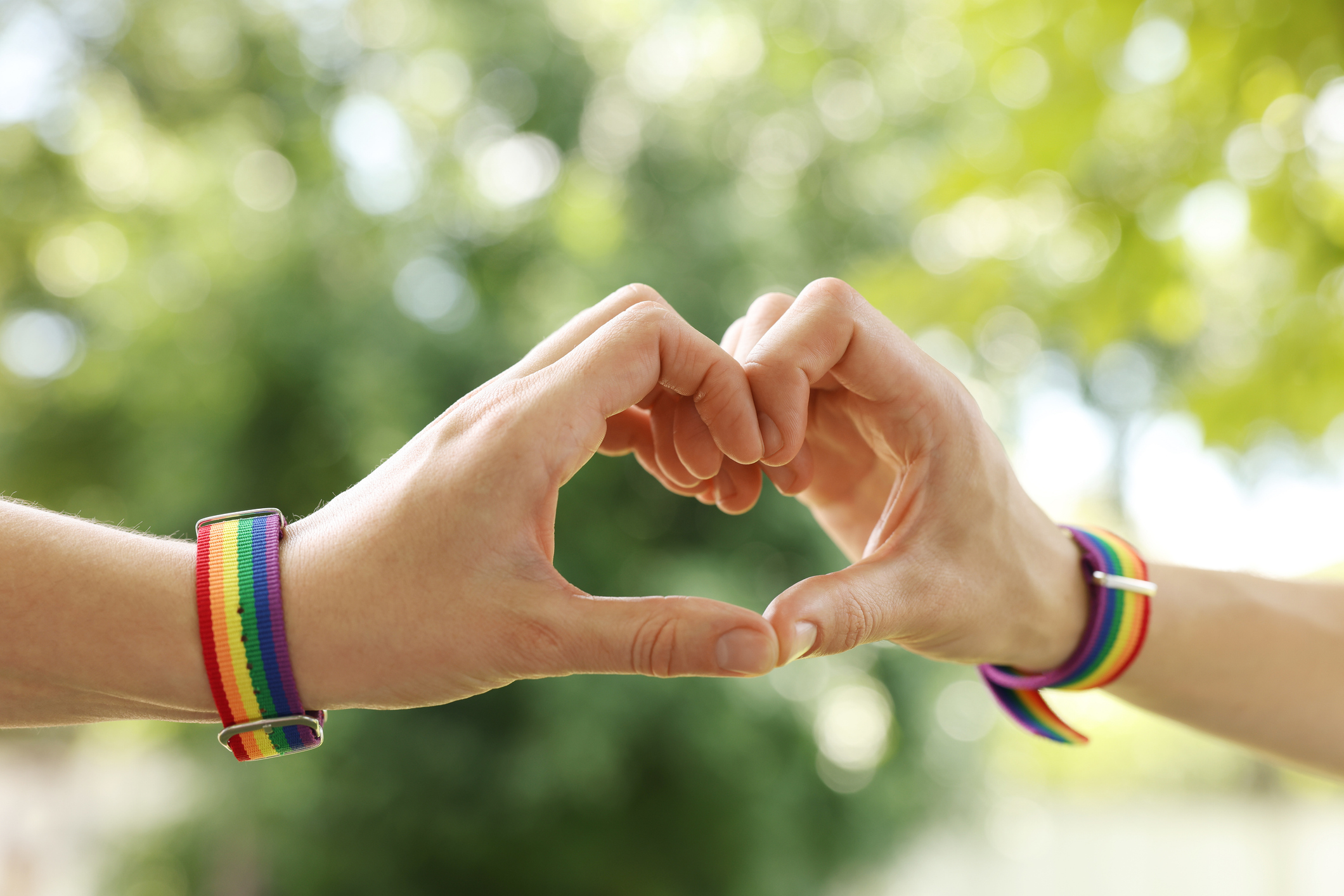 Two women's hands create a heart with trees in the background near Chipeta Lodge Resort + Spa
