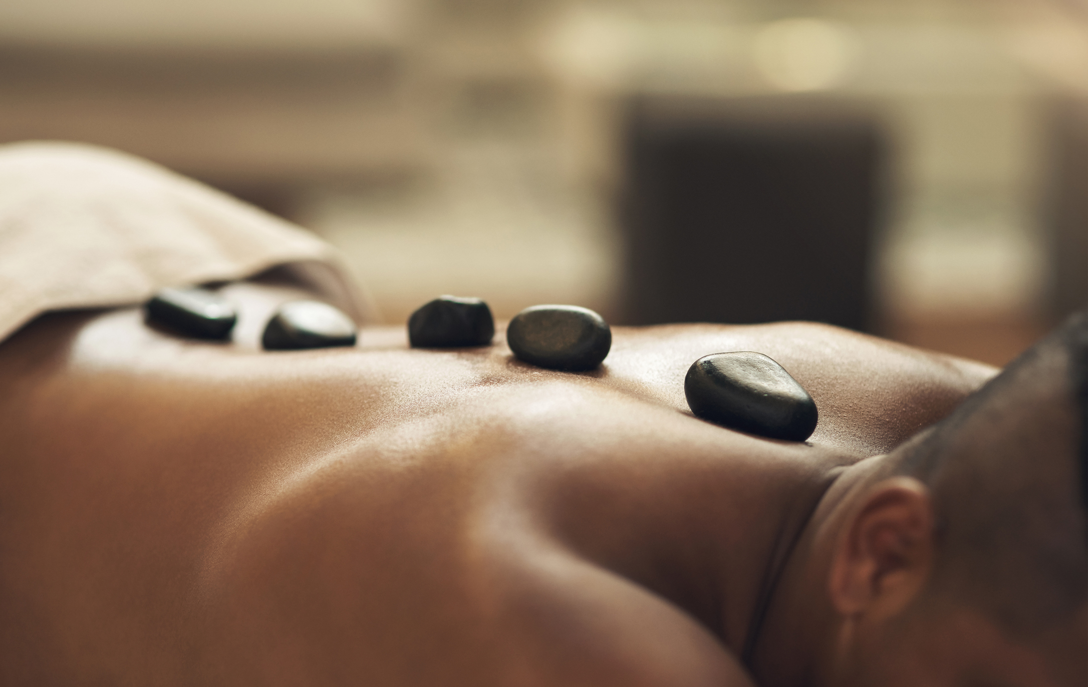 Man receiving a hot stone massage at Chipeta Spa by ISUN at Chipeta Lodge Resort + Spa